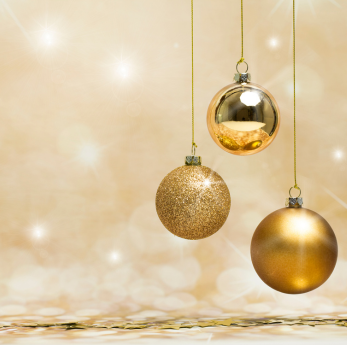 Three gold Christmas baubles — one glittery, one shiny, one matte — hang against a warm golden bokeh